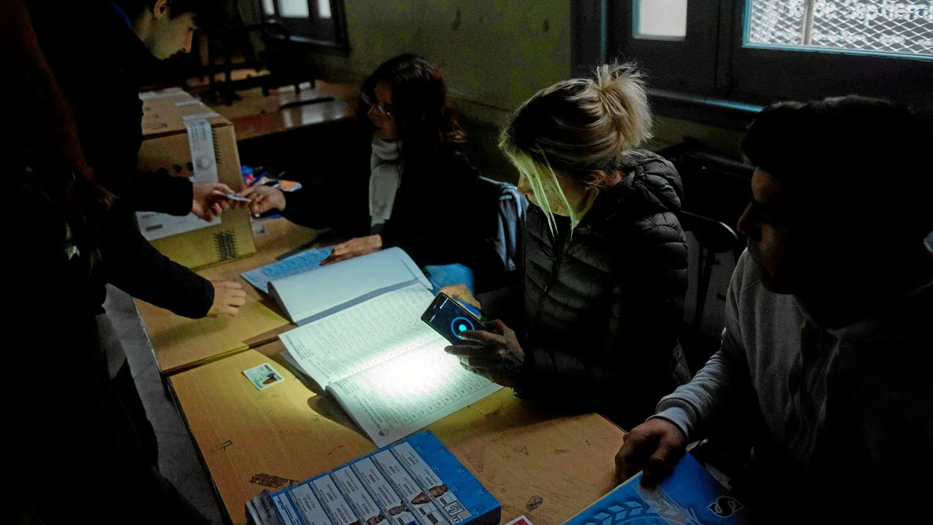 Algunos ciudadanos acudieron a votar en Rosario en pleno apagón, ayudados por la linterna del móvil / Efe