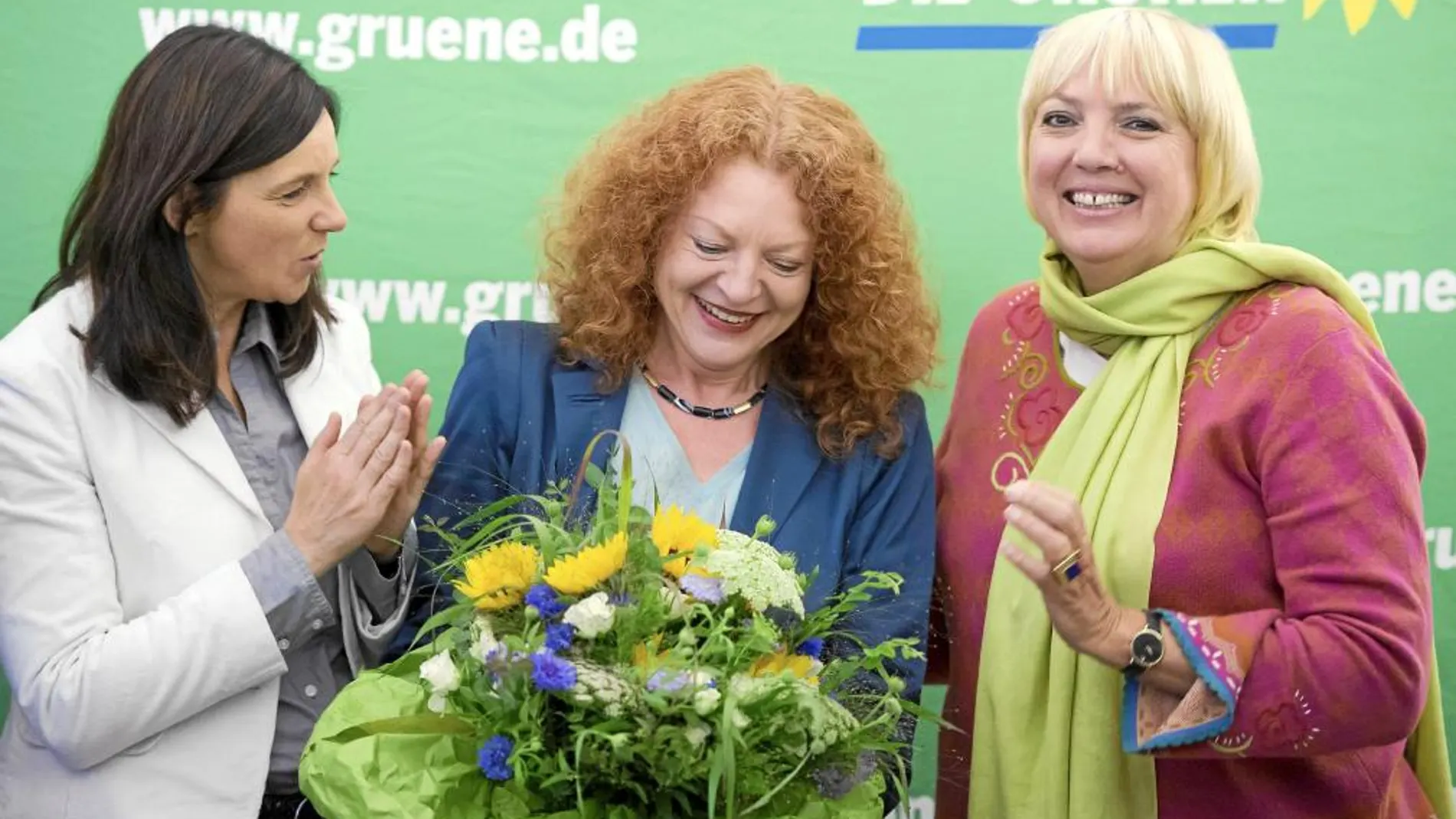 La líder de Los Verdes, Claudia Roth (dcha.), entrega unas flores a su candidata en Bavaria, Margarete Bause