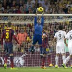 El portero del F.C. Barcelona Víctor Valdés (c) detiene un balón durante el partido
