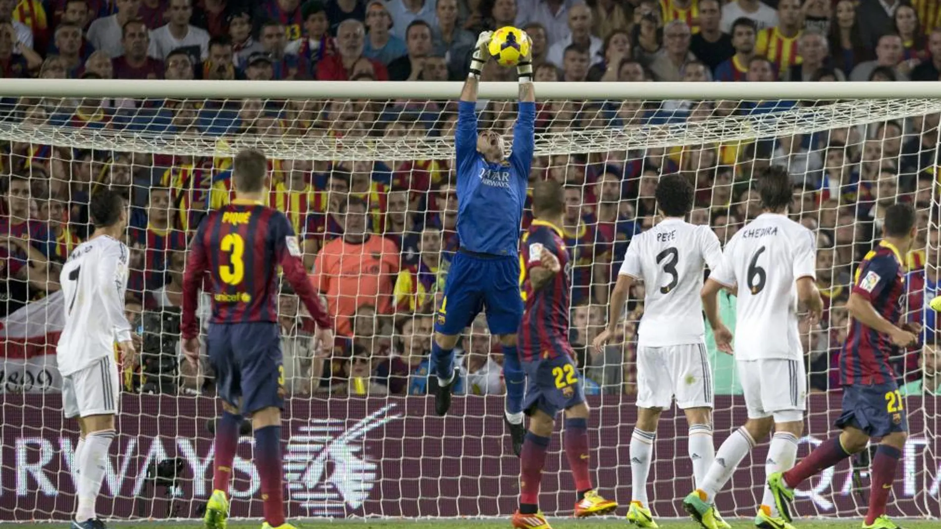El portero del F.C. Barcelona Víctor Valdés (c) detiene un balón durante el partido