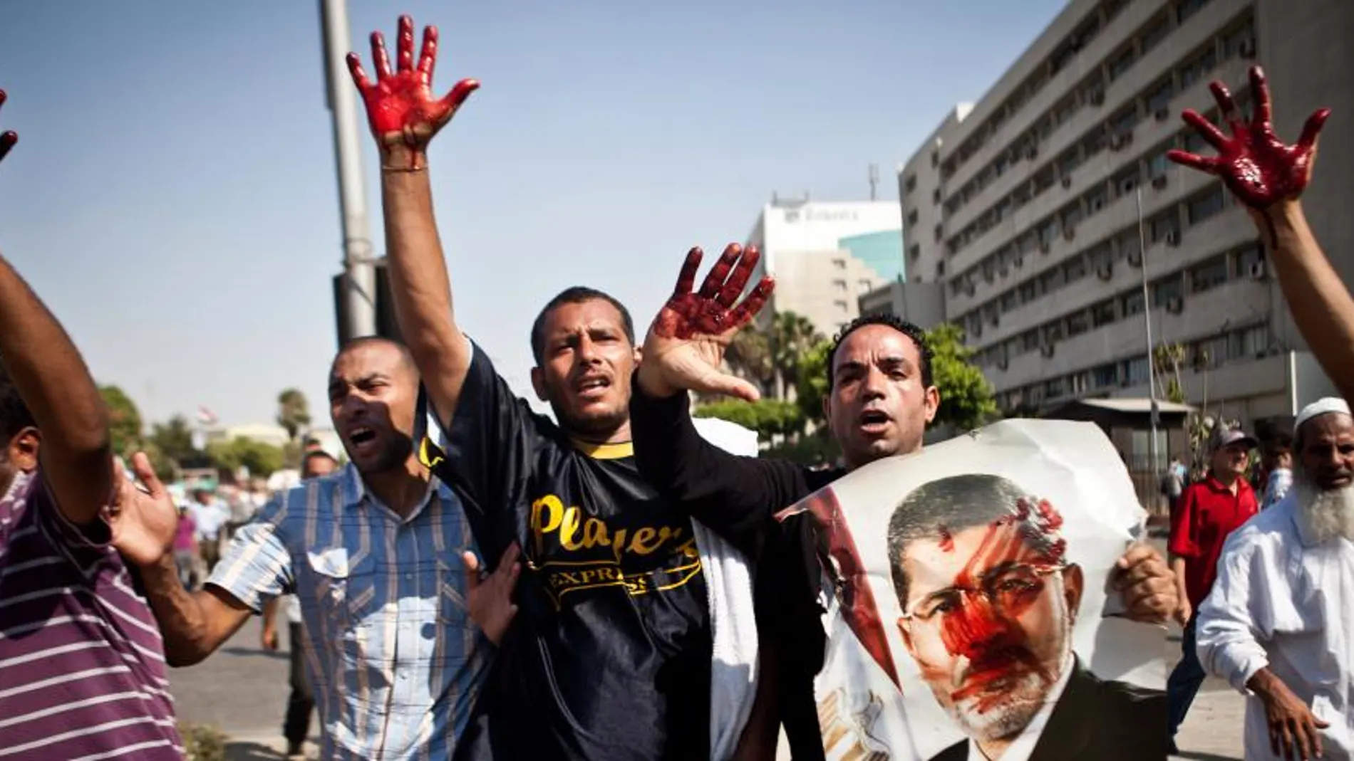 Simpatizantes del presidente depuesto Mohamed Mursi protestancon las manos manchadas de sangre