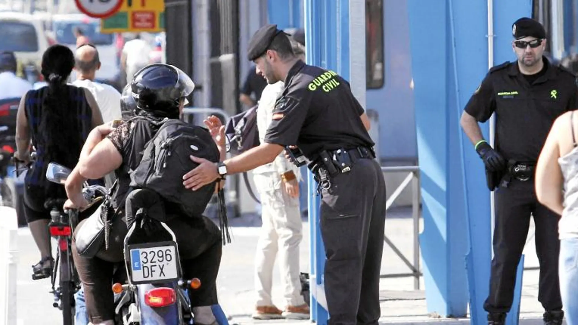Un agente palpa la mochila de un motorista en la Verja con Gibraltar, mientras el SUP y la AUGC denuncian los acosos