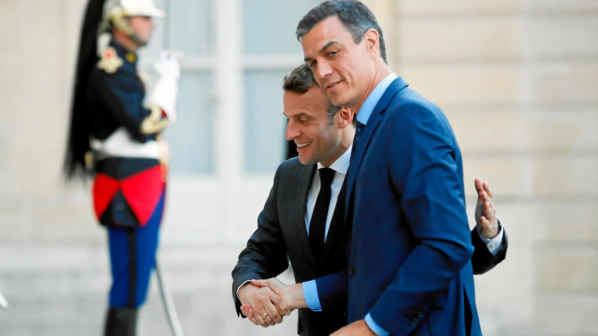 Emmanuel Macron y Pedro Sánchez se estrechan la mano en el Elíseo, donde compartieron cena antes de la cumbre de hoy en Bruselas