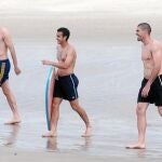 Javi Martínez, Pedro, con su tabla, y Valdés salen del agua, tras un relajante baño en la playa de Fortaleza