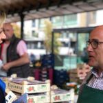 Pilar del Olmo conversa con un comerciante del mercado de frutas y verduras de Plaza España