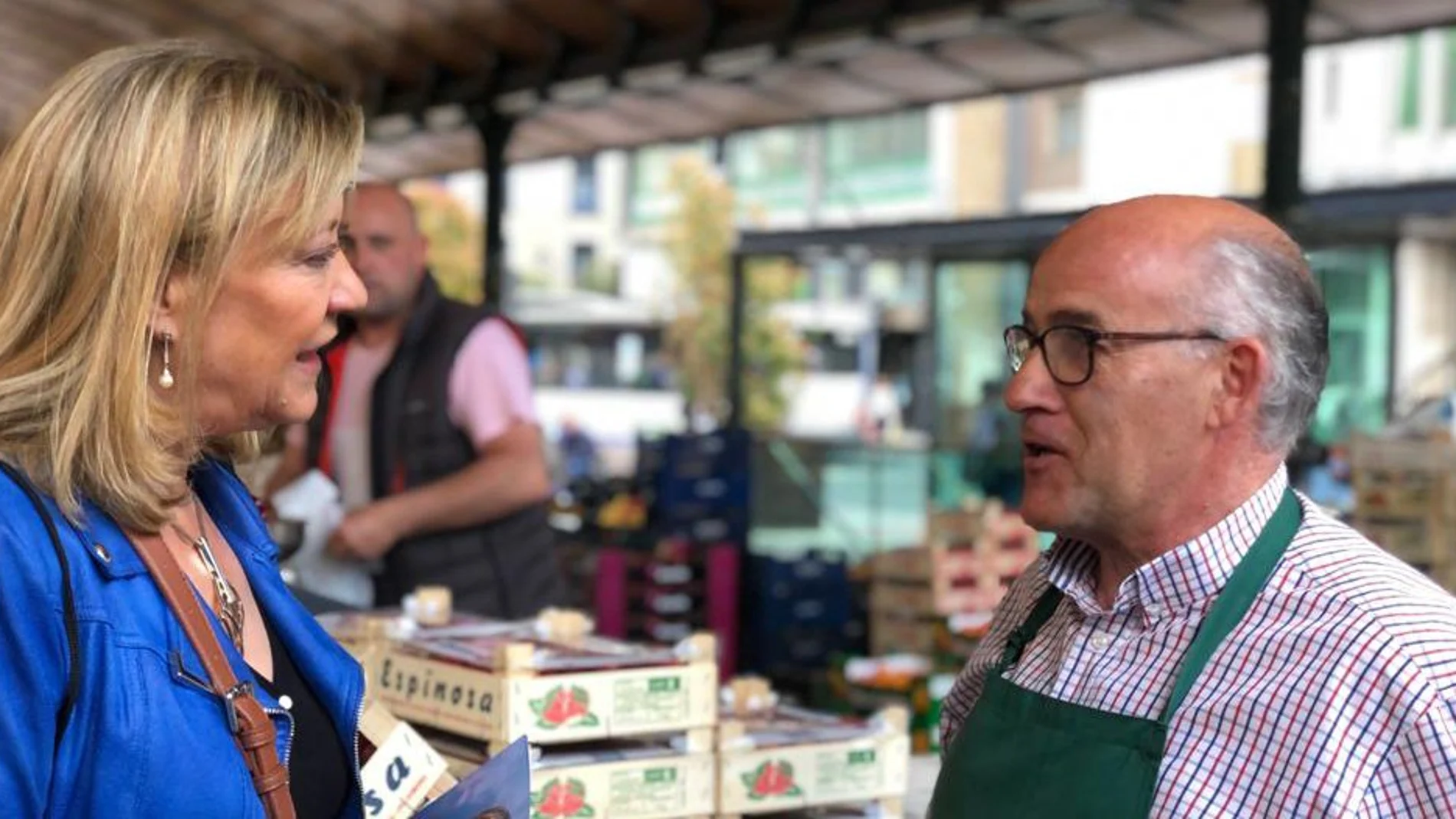 Pilar del Olmo conversa con un comerciante del mercado de frutas y verduras de Plaza España