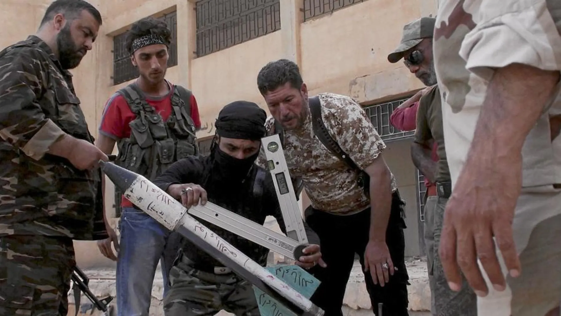 Militantes del Ejército Libre de Sira se preparan ayer para lanzar un cohete