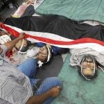 Un miembro de los Hermanos Musulmanes posa junto a varios de los seguidores de Mursi que fallecieron la madrugada de ayer, en El Cairo