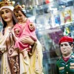 Una figura del fallecido presidente Chávez junto a la de la Virgen, en una tienda de articulos religosos en Caracas