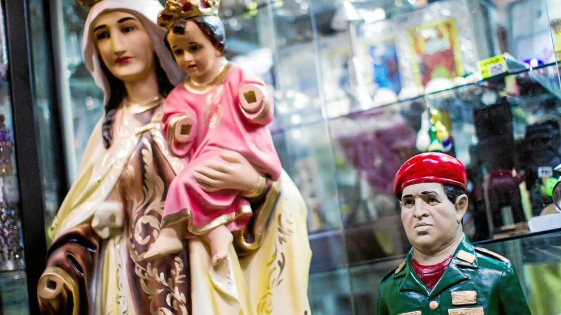 Una figura del fallecido presidente Chávez junto a la de la Virgen, en una tienda de articulos religosos en Caracas
