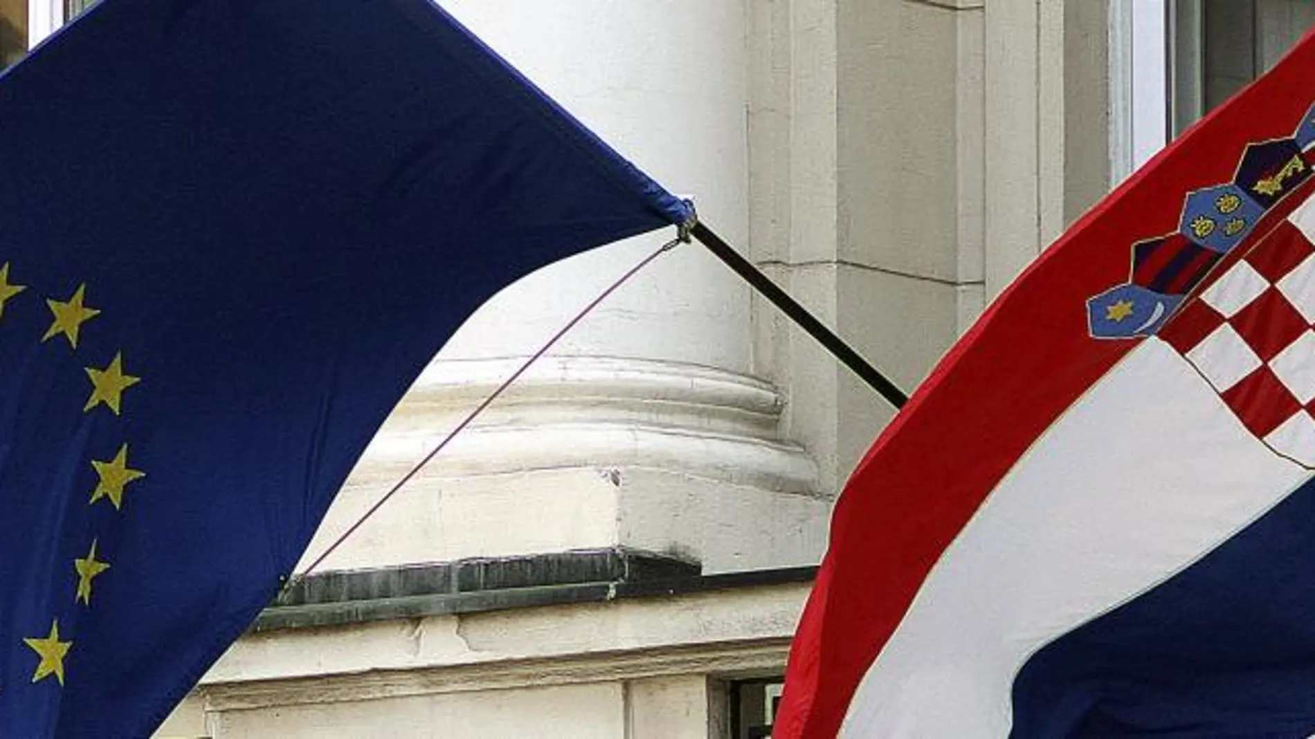 Una bandera croata (dcha) y otra de la Unión Europea (izda) ondean en un edificio del gobierno en Zagreb (Croacia)