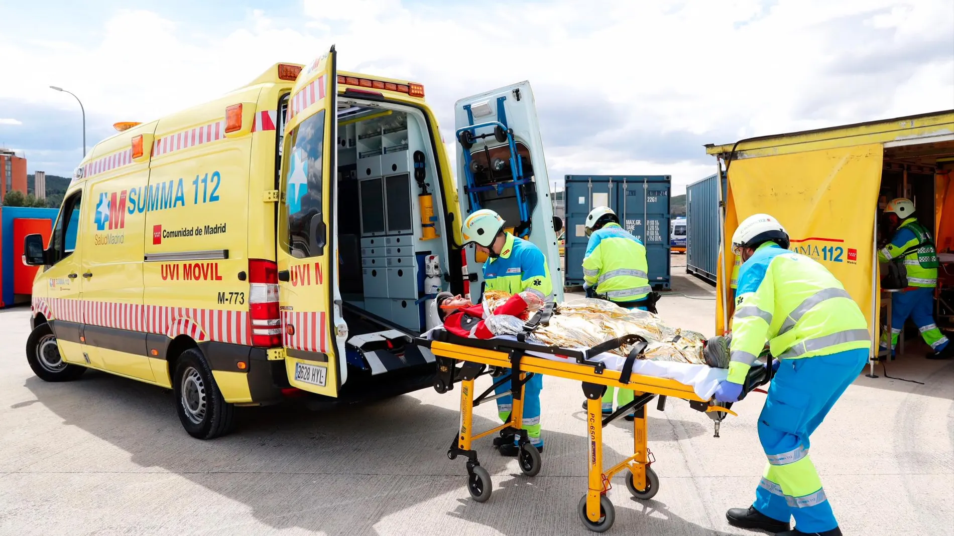 Dos técnicos sanitarios de Summa trasladan a un herido simulado a una ambulancia