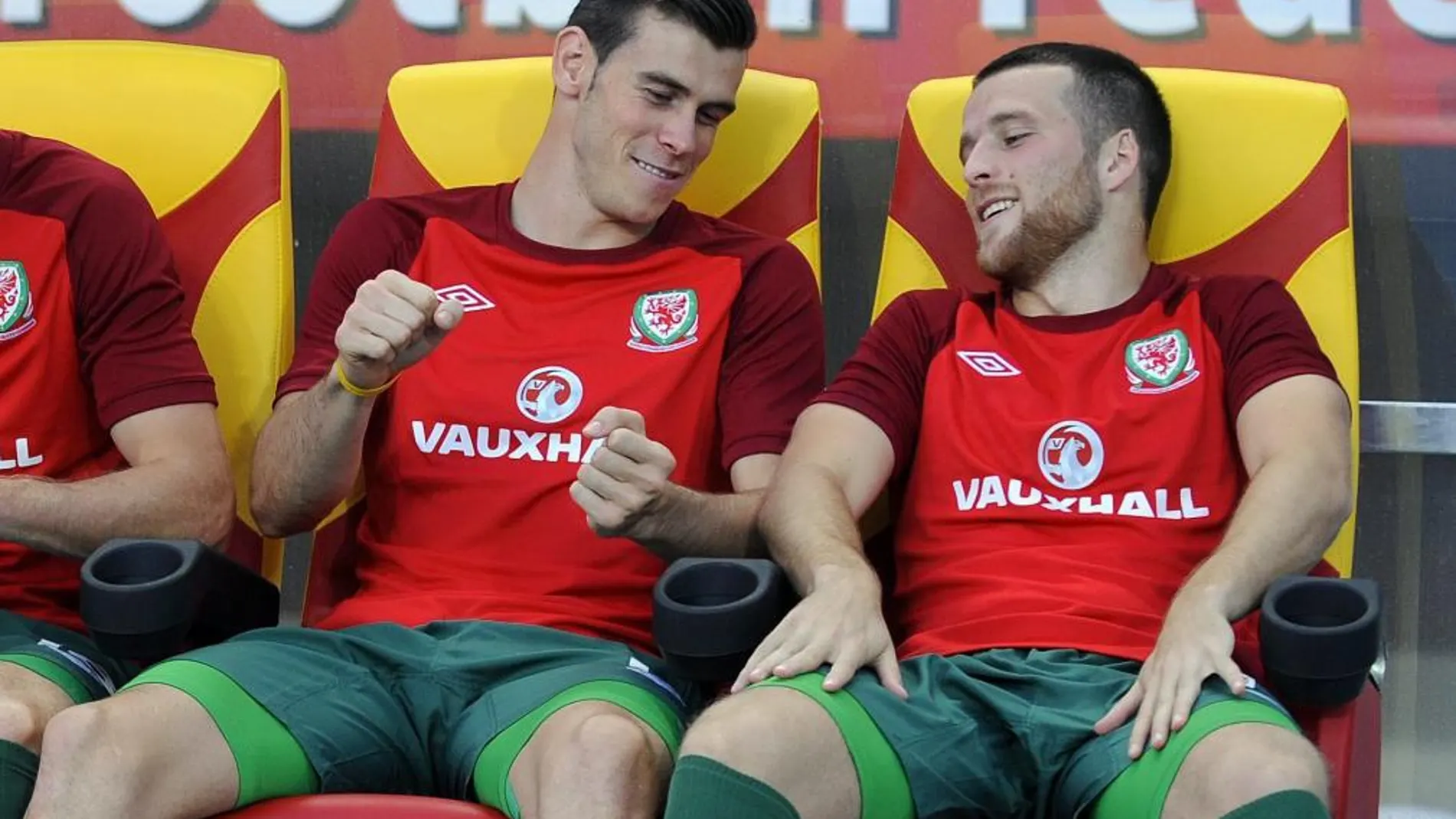 El internacional galés Gareth Bale, quien ha fichado recientemente por el Real Madrid, bromea en el banquillo con un compañero durante el partido Macedonia-Gales
