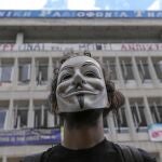 Un hombre con careta protesta frente a la sede de la televisión pública griega, en Atenas