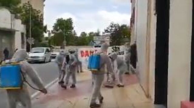 Un grupo de personas vestidas con un mono blanco, rocía lejía y friega el suelo por donde los representantes de Ciudadanos estaban paseando / Twitter @Albert_Rivera