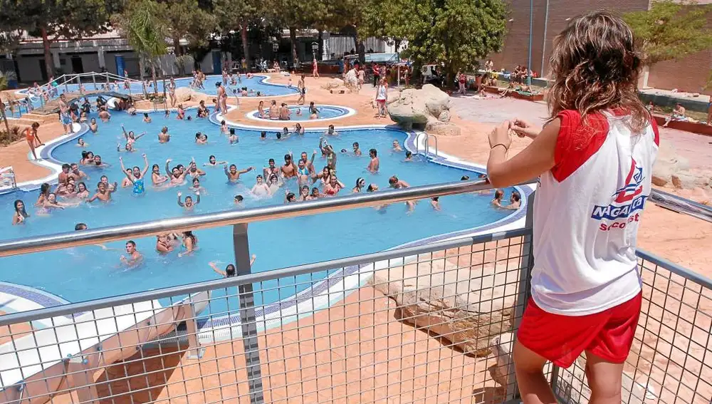 Un socorrista controla a los bañistas de una piscina en la Comunitat