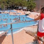 Un socorrista controla a los bañistas de una piscina en la Comunitat