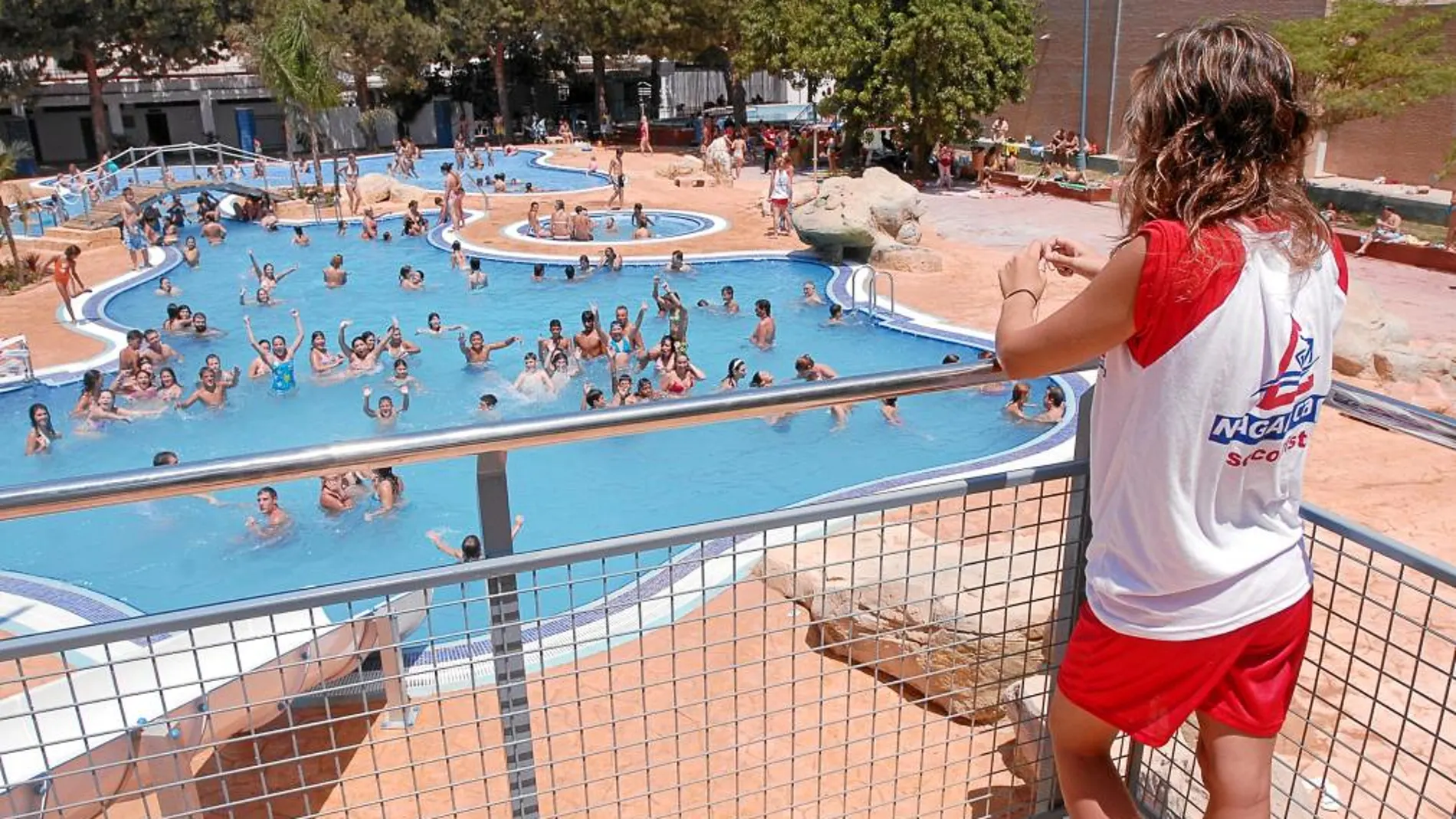 Un socorrista controla a los bañistas de una piscina en la Comunitat