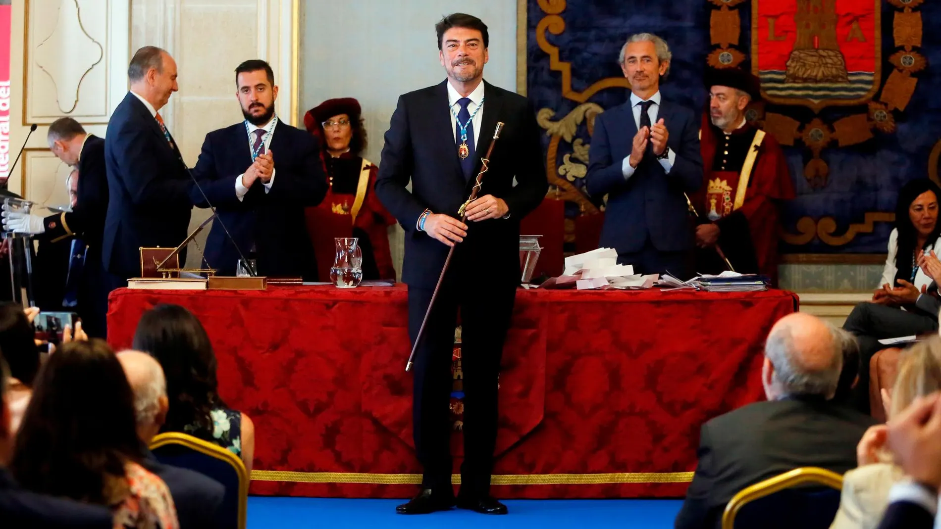 El alcalde de Alicante, Luis Barcala, posa con la vara de mando tras ser investido este sábado en el que la mayoría de los ayuntamientos de la Comunitat Valenciana celebran sus sesiones constitutivas. EFE /Manuel Lorenzo