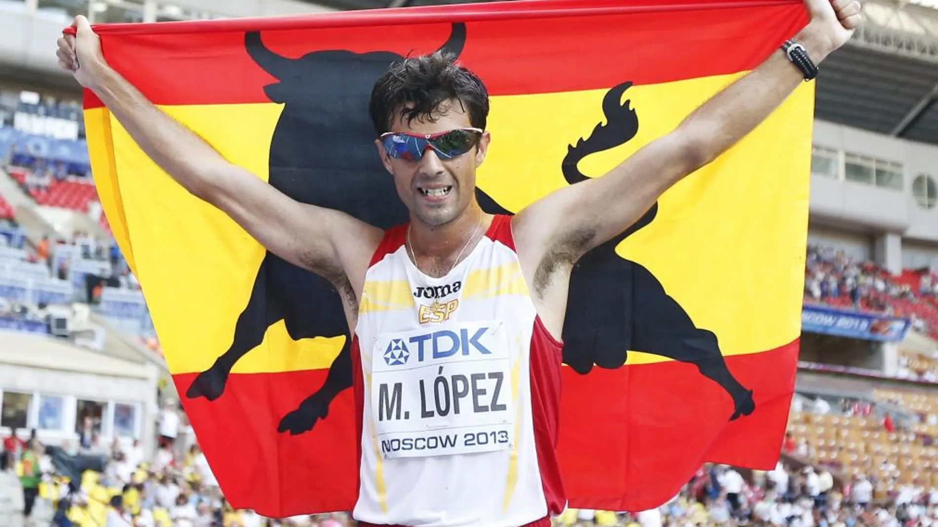 Miguel Ángel López celebra con la bandera de España el tercer puesto en los 20 kilómetros marcha
