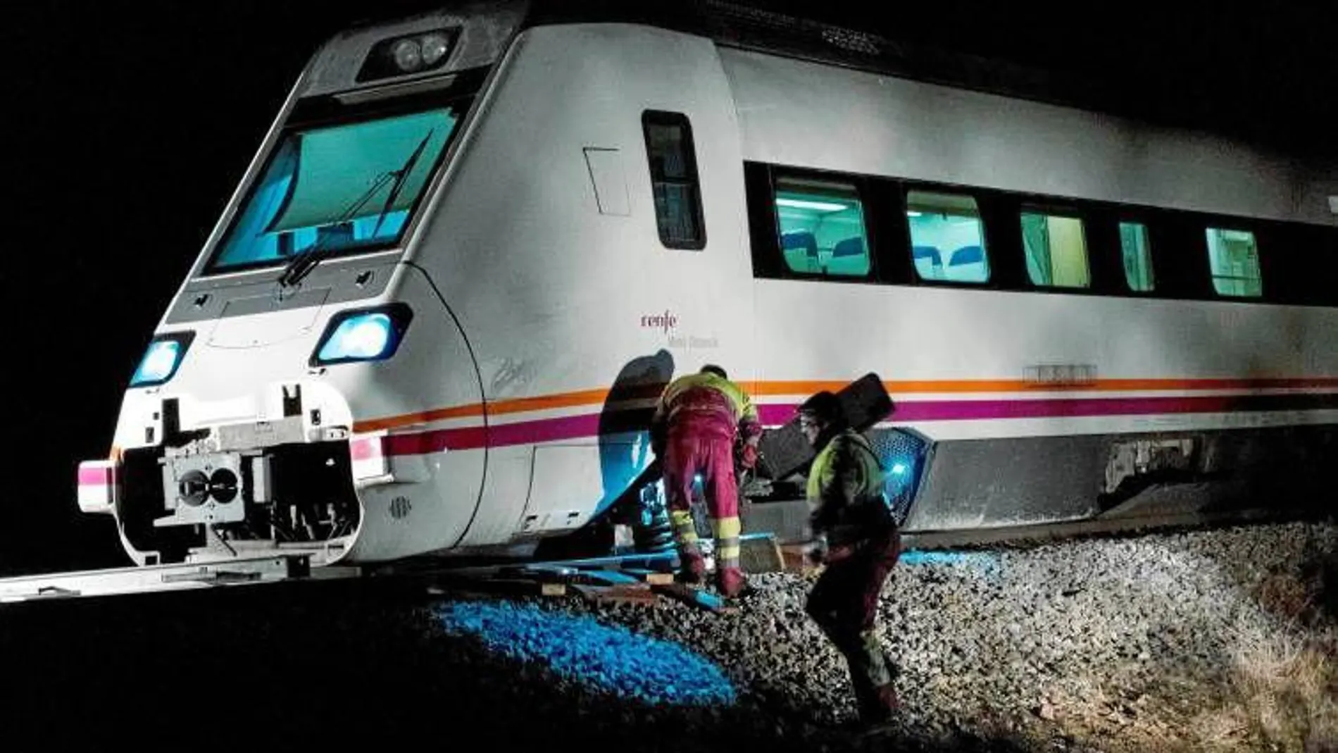Un par de operarios tratan de reparar una avería en un tren de la línea de Extremadura