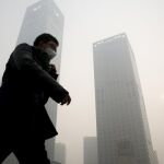 China es el mayor emisor de dióxido de carbono. En la imagen, un hombre con una máscara camina por el distrito financiero de Beijing / Foto: Reuters