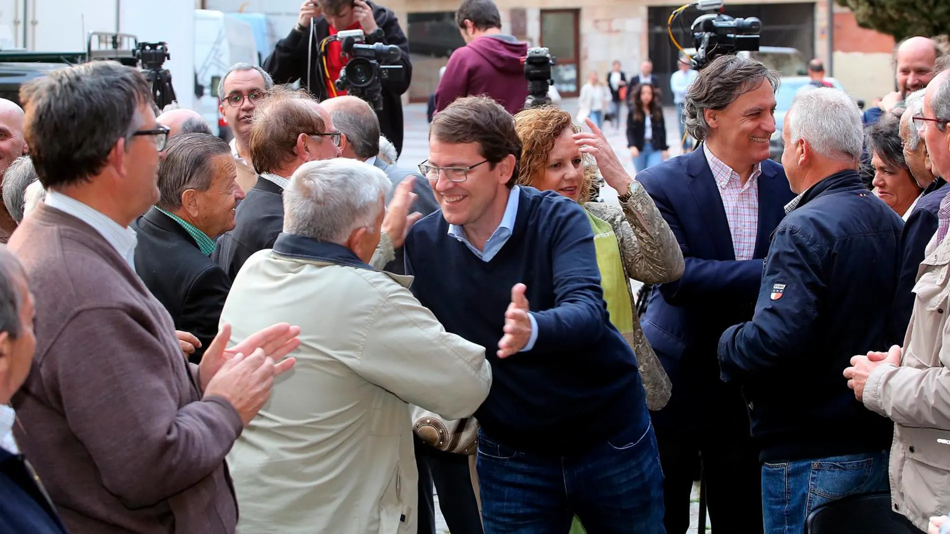 Fernández Mañueco saluda a los simpatizantes a su llegada al acto de Salamanca junto al alcalde de la ciudad, Carlos García Carbayo