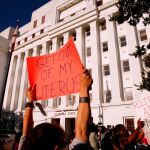 Un grupo de manifestantes en frente de la Cámara Estatal de Alabama