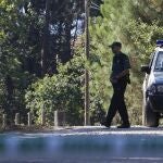 Agentes de la Guardia Civil custodian una pista forestal de Cacheiras ,donde fue hallado el cadáver de una niña de 12 años con signos de violencia.