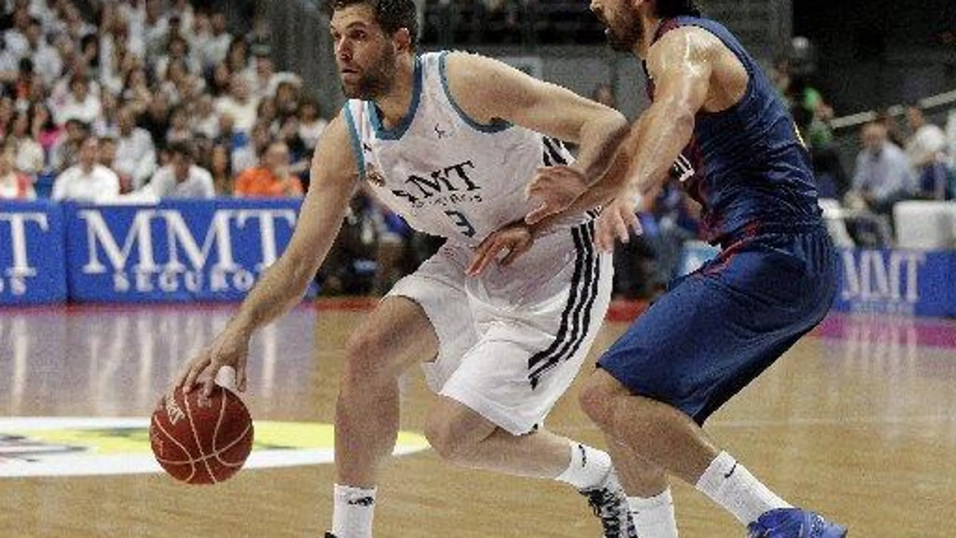 El ala-pívot del Real Madrid Felipe Reyes con el balón ante el base del FC Barcelona Víctor Sada,