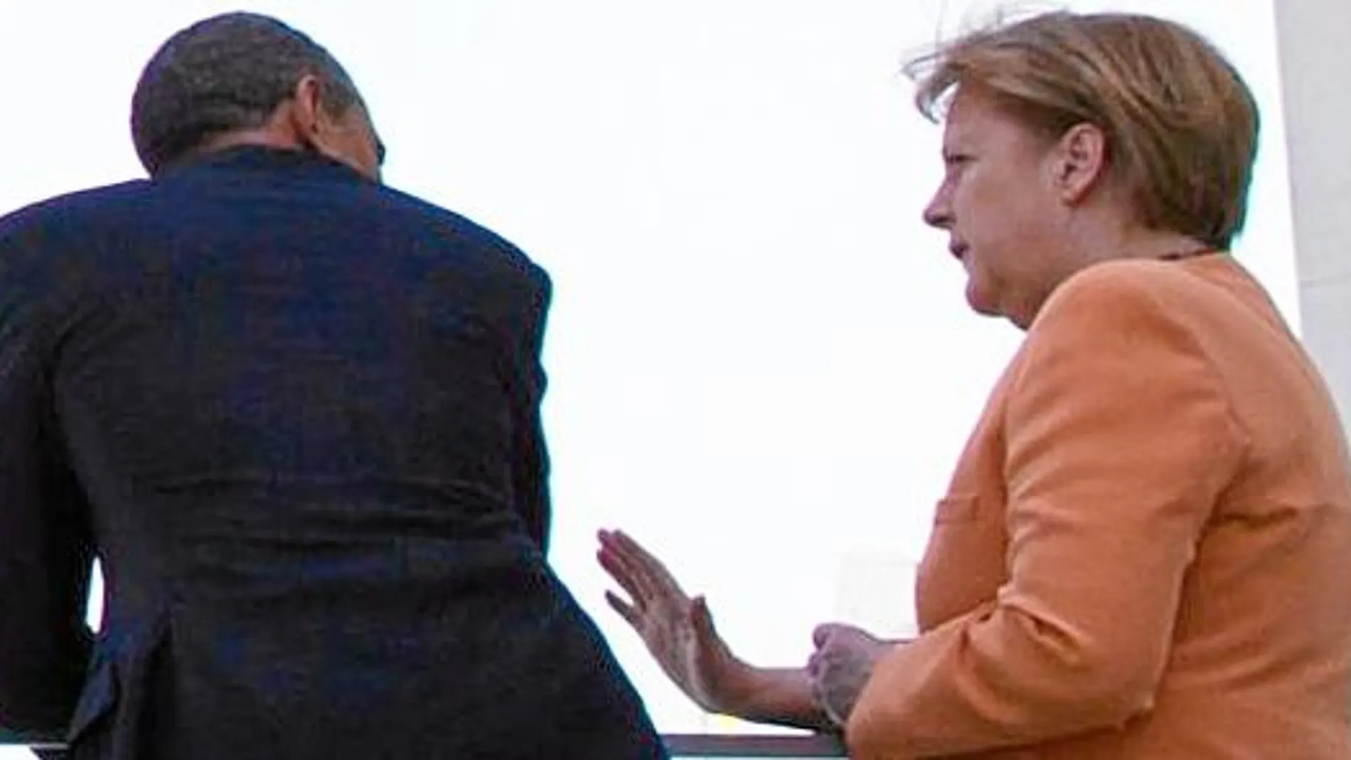 El presidente y la canciller conversan en el balcón de la Cancillería en Berlín, en junio