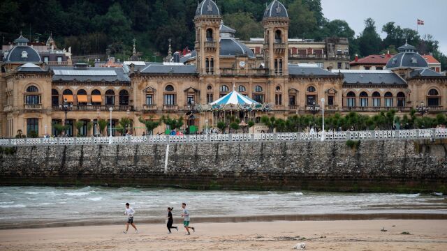 Varias personas corren por la playa de La Concha de San Sebastián. EFE/Javier Etxezarreta