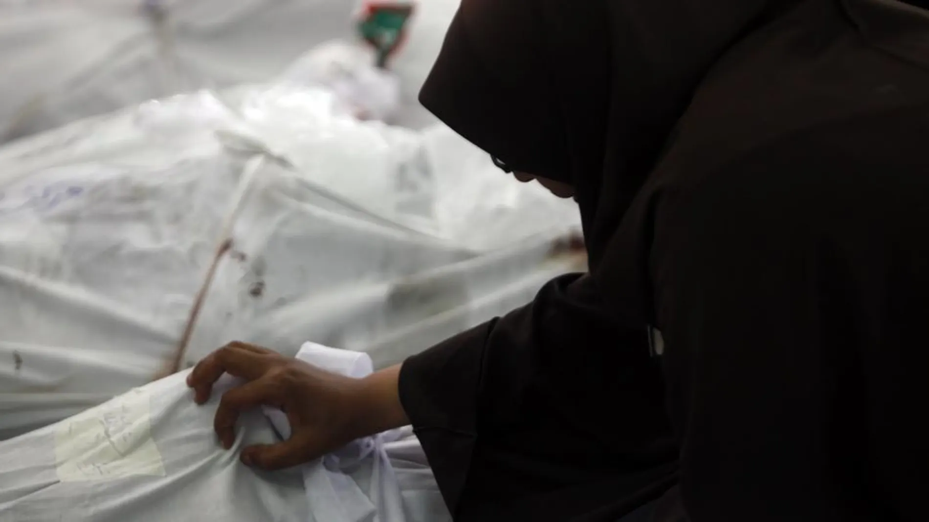 Una mujer llora sobre el cadáver de su marido, muerto ayer en los enfrentamientos con la policía en El Cairo