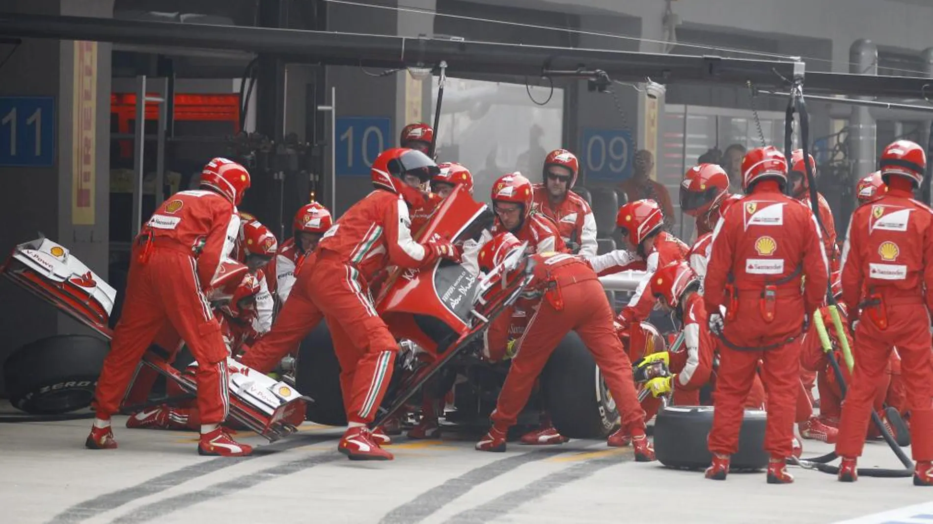El piloto de Ferrari Fernando Alonso, a su paso por el pit stop del GP de India, en el que sufrió un choque en la primera vuelta