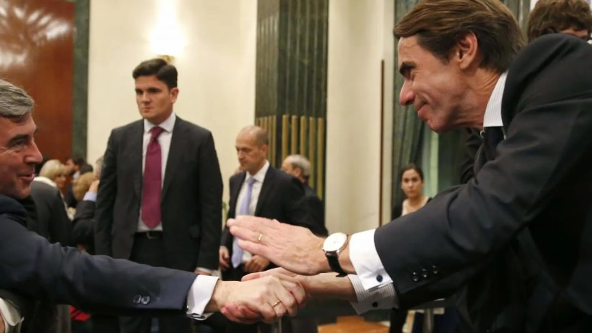 José María Aznar saluda a Ángel Acebes durante la presentación de la segunda parte de sus memorias