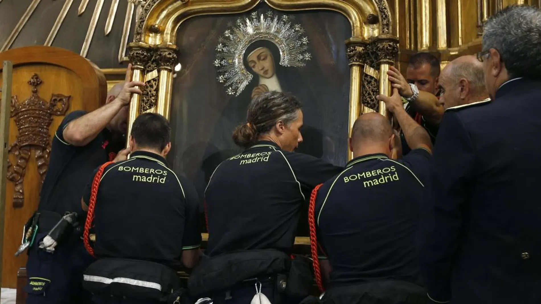 Integrantes del cuerpo de Bomberos durante la bajada del cuadro de la Virgen de la Paloma del año pasado