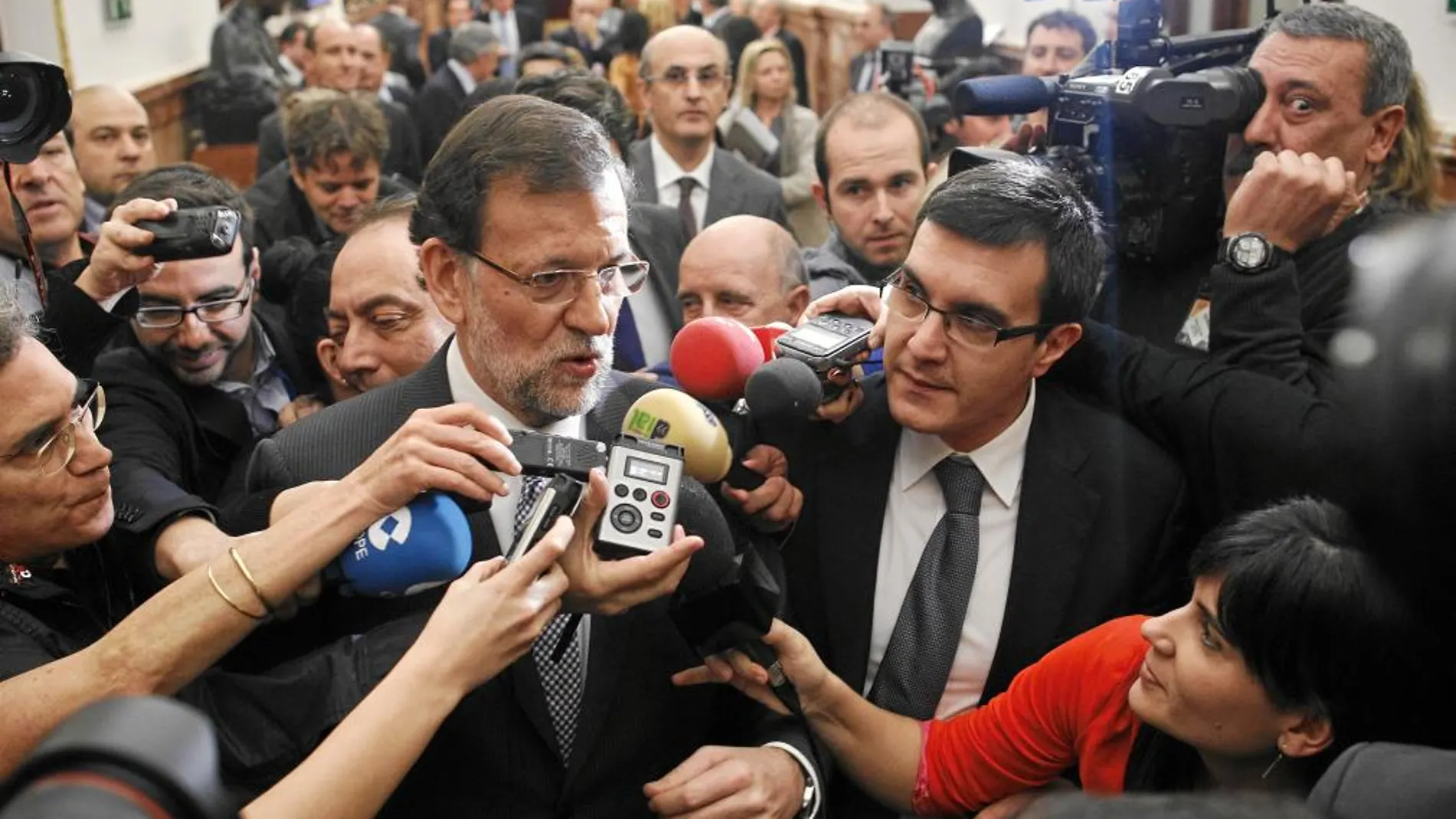 El presidente del Gobierno, Mariano Rajoy, atiende a los medios en los pasillos del Congreso