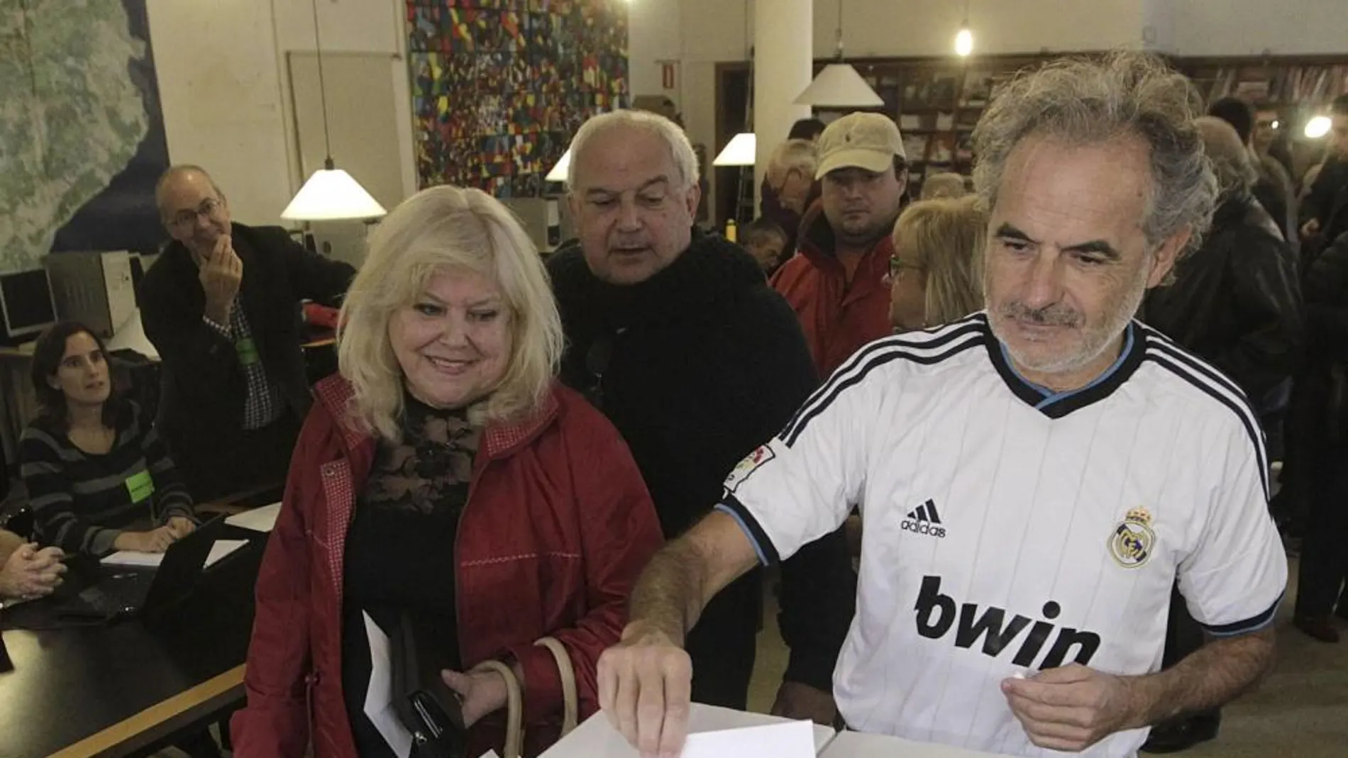 Un ciudadano, vestido con la camiseta del Real Madrid, deposita su papeleta, en el Institut Montserrat de Barcelona.