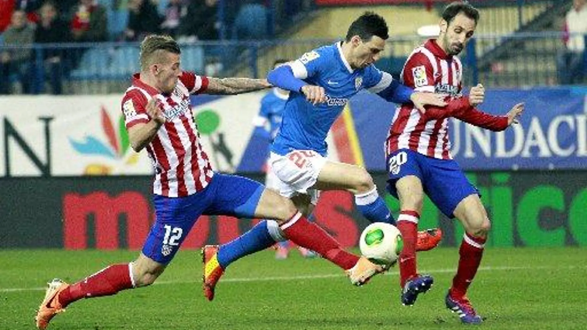 El delantero del Athletic de Bilbao Aritz Aduriz (c) trata de escapar entre el belga Alderweireld (i) y Juanfran,