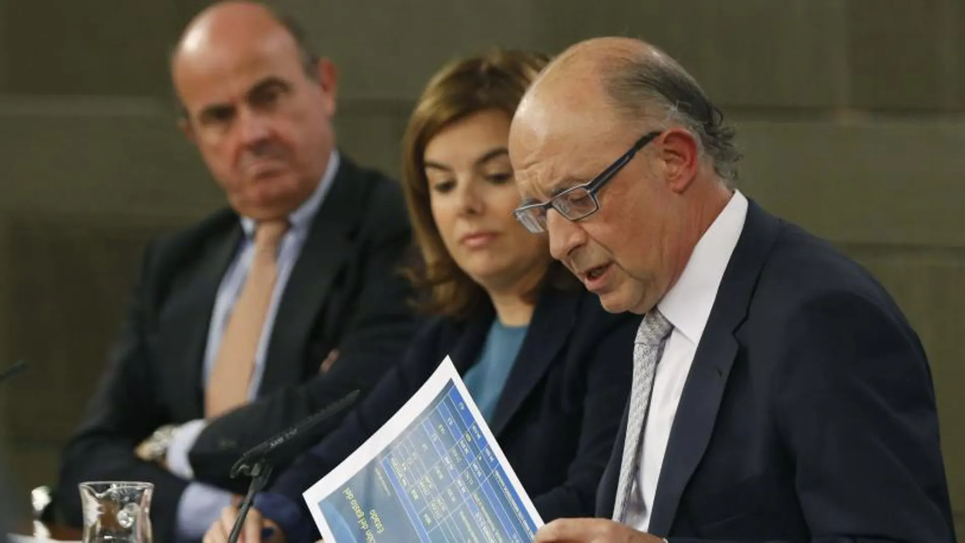 Cristóbal Montoro, junto a Soraya Sáenz de Santamaría y Luis de Guindos, durante la rueda de prensa ofrecida tras la reunión del Consejo de Ministros.