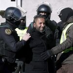 Agentes de la Guardia Civil trasladan a uno de los cuatro detenidos