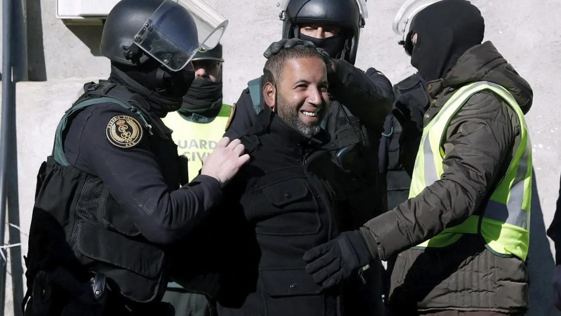 Agentes de la Guardia Civil trasladan a uno de los cuatro detenidos