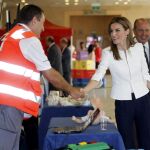 La Reina Letizia saluda a uno de los voluntarios durante el acto conmemorativo del 150 aniversario de la fundación de Cruz Roja.