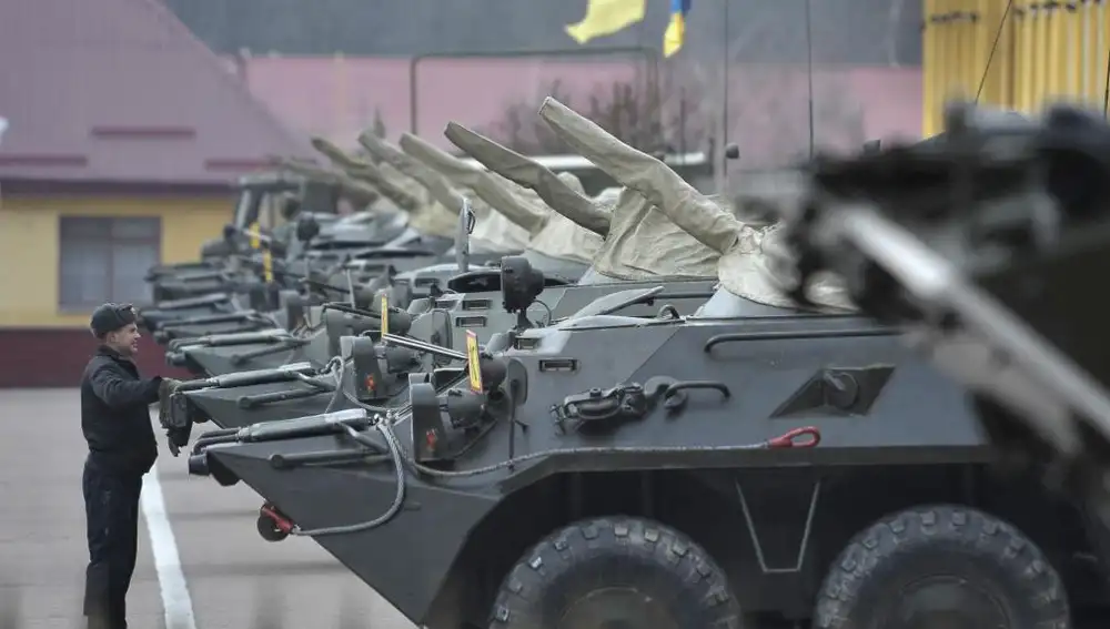 Un soldado ucraniano inspecciona vehículos armados en una base militar en Lviv (Ucrania)