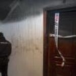 Un policía custodia la puerta del piso en el han fallecido una mujer y su nieta