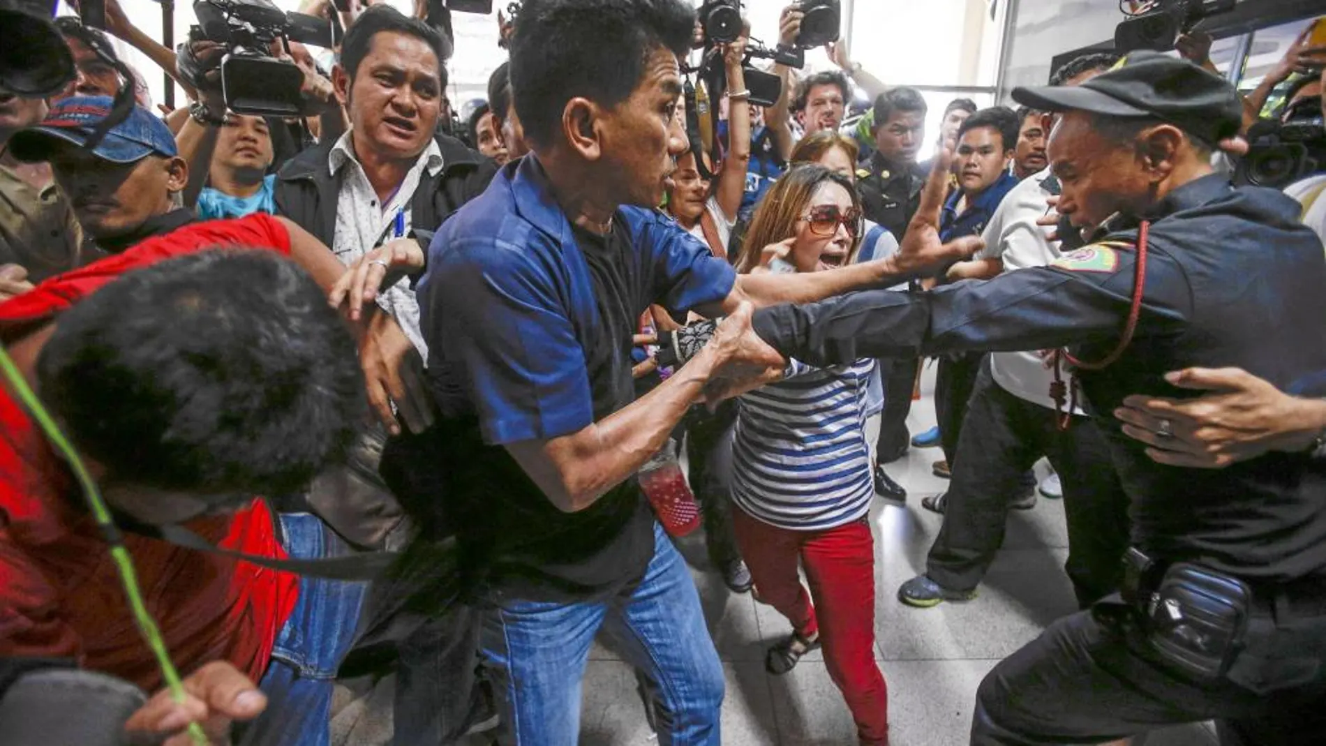 Manifestantes se enfrentan a un funcionario en un distrito de Bangkok en el que se canceló ayer la votación
