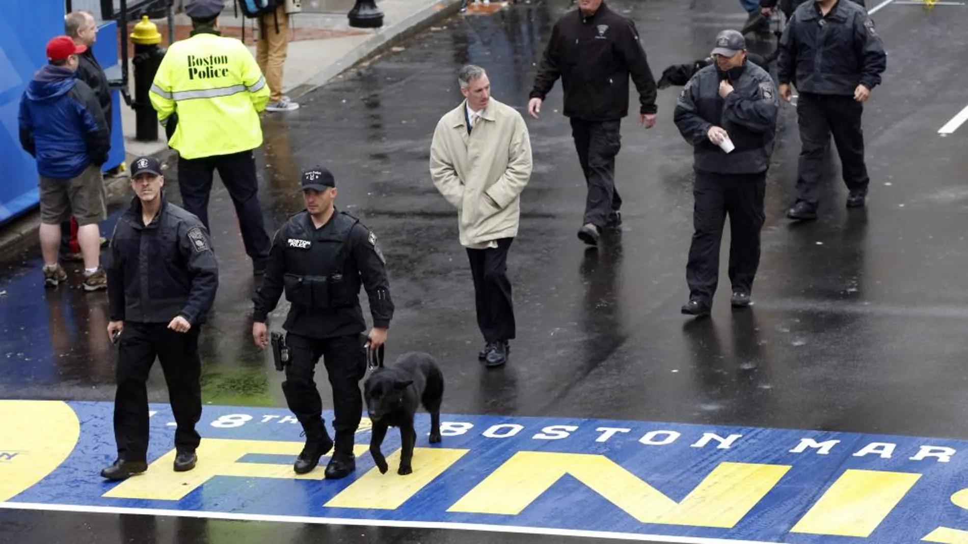 Personal de seguridad cruza la meta del maratón de Bostón antes de la ceremonia en recuerdo de las víctimas del atentado de 2013