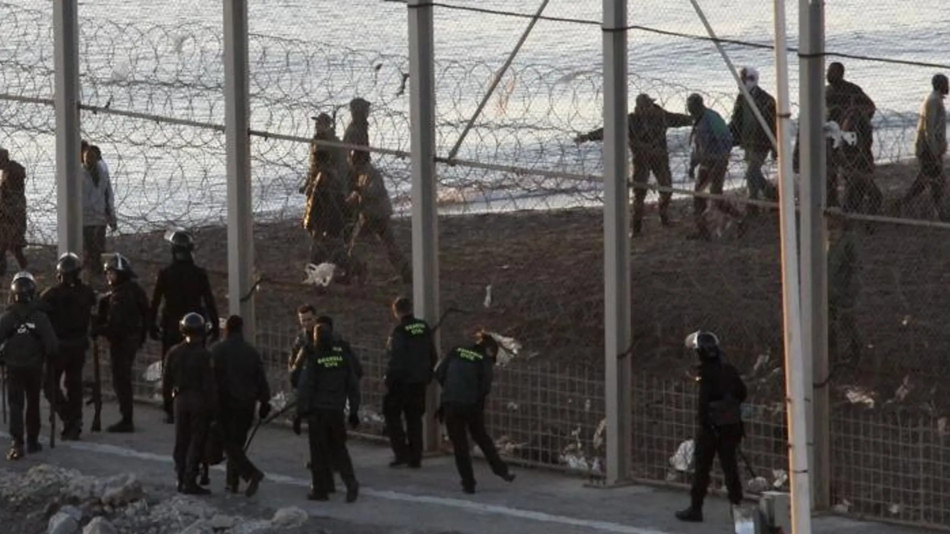 Miembros de la Guardia Civil, junto a la valla que separa Ceuta de Marruecos.