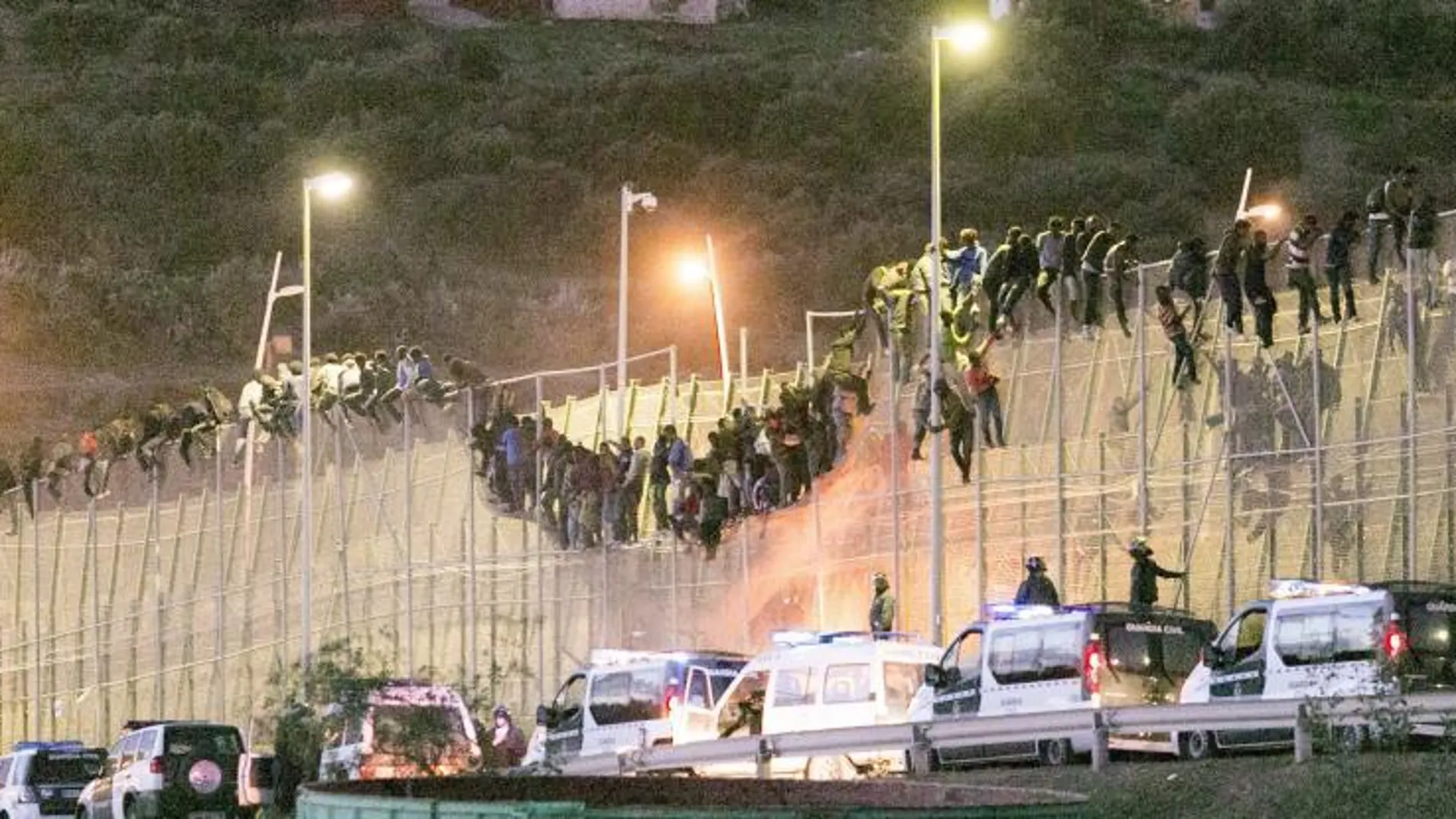 Los inmigrantes encaramados a la valla de Melilla