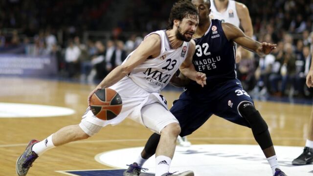 El jugador del Real Madrid Sergio Llull (i) pelea por el balón ante el defensa del Anadolu Efes Scotty Hopson